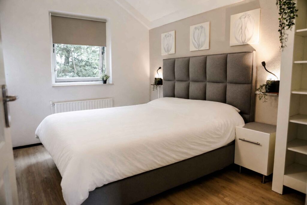 Tweepersoonsslaapkamer met groot bed en kastruimte