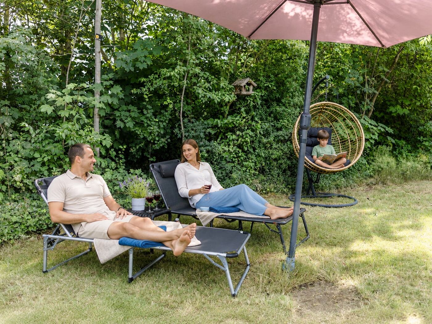 Gezin ontspant op de ligbedden in de grote privétuin